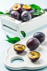 Ripe plums in a box. Selective focus, space for text.