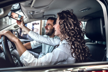 Young couple in love choosing car dealership.