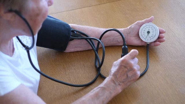 Grandmother Checking Blood Pressure With Tonometer At Home