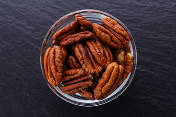 delicious pecan nuts on a dark stone background