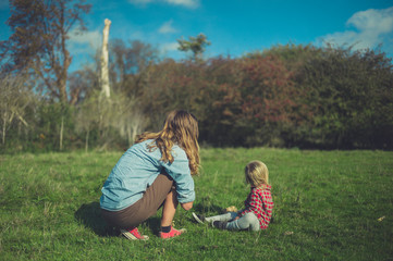 Mother and toddler relaxing in meadow