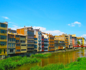Colorful yellow and orange houses reflected in water river, in Girona, Catalonia, Spain.