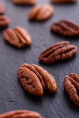 delicious pecan nuts on a dark stone background