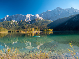 Image of stand up paddling on a beautiful mountain lake in autumn