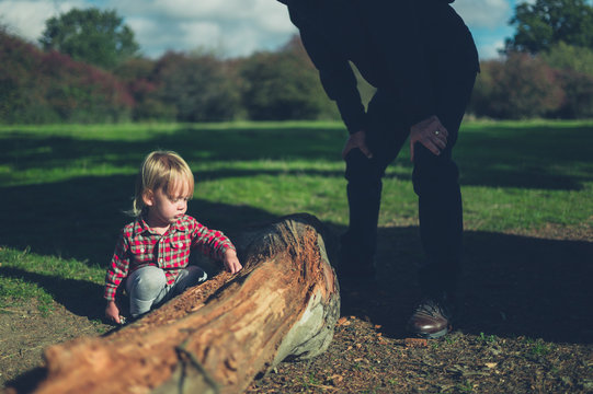 Toddler and grandfather looking at a log
