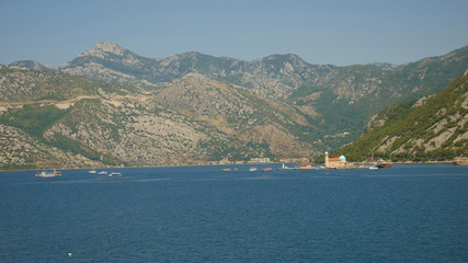 Picturesque view of the waters of the Bay of Kotor and the high mountains rising in the background.