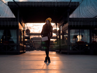 woman stands in sunset, blur bokeh background