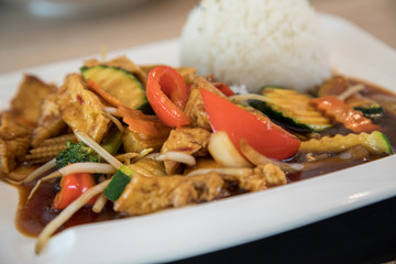 Vegetarisch Tofu Gemüse aus Wok mit pikanter, brauner Szechuan Soße und Reis im Restaurant