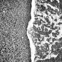 Fototapeta premium Vague s'échouant sur la plage en noir et blanc 