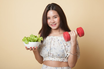 Healthy Asian woman with dumbbells and salad.