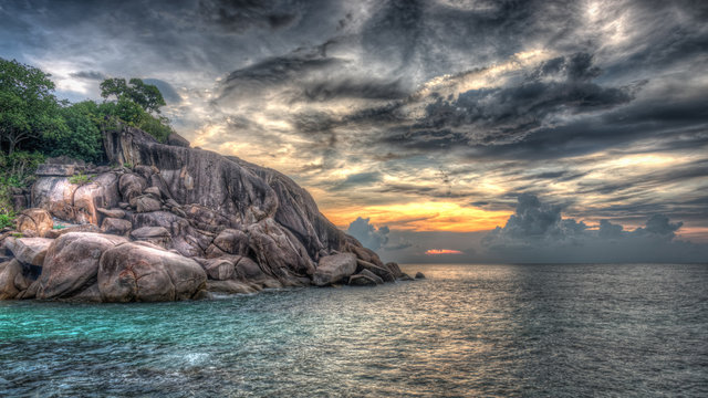 Dramatischer Sonnenuntergang mit Felsklippen am Meer