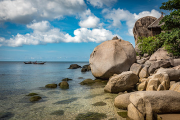 Felsenküste mit Meer und Longtail Boat