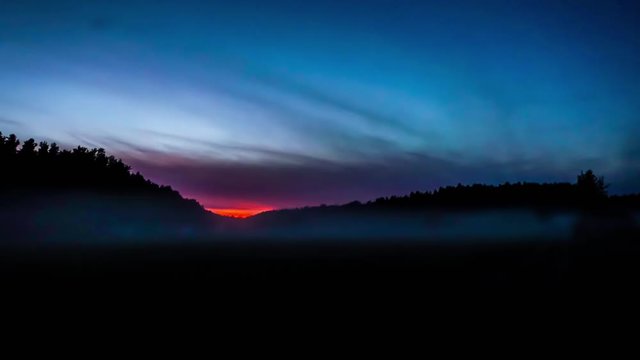 Timelapse of late evening mist when red sun is rising