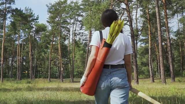 Female archer going through the forest.