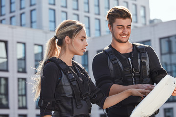 positive man and woman pushing on screen. close up side view photo. man teaching a woman to train...