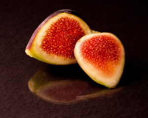 Close-up of sliced fig with its reflection.