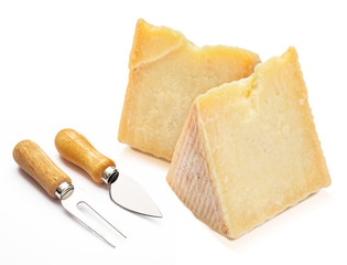 Cured sheep cheese (Manchego type) in wedge and cutlery. Isolated on white background.