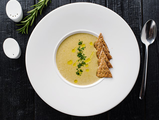 Mushroom cream soup with crackers in a white plate. Concept for a menu in a restaurant. Top view.