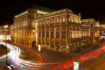 Vienna State Opera at night with car light trails on the Vienna Ring street.
