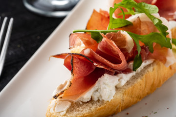Bruschetta with Parma and goat cheese, olives and almonds. Wine set