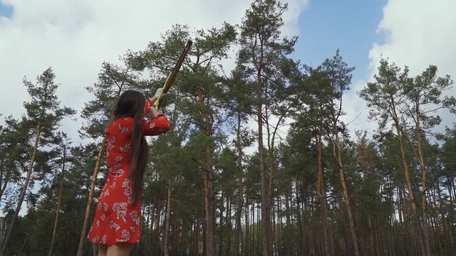 Girl in a red dress launched an arrow into the sky