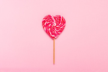 Lollipop on a gently pink background. Heart shape. Flat lay, top