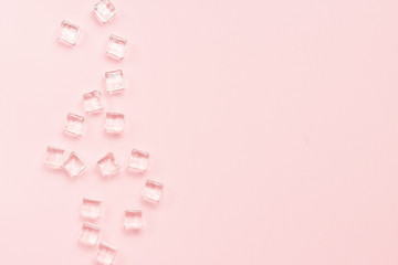 Ice cubes on a light pink background. Flat lay, top view