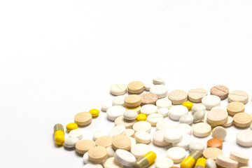 Pills of different sizes and colors and on a white isolated back