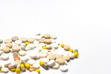 Pills of different sizes and colors and on a white isolated back