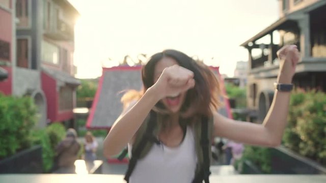 Slow motion - Cheerful beautiful young Asian backpacker blogger woman feeling happy dancing on street while traveling at Chinatown in Beijing, China. Lifestyle backpack tourist travel holiday concept.