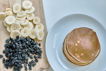 Sliced ​​bananas, blueberries, raisins, pigeons, lie on the table.