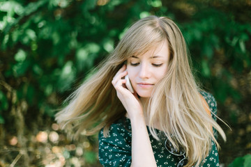Naklejka premium Beautiful young woman talking over mobile phone outdoor