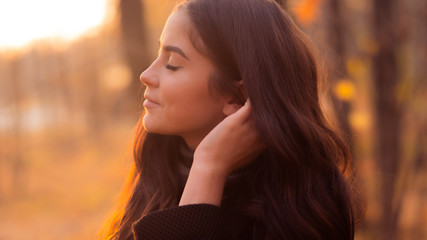 Fototapeta premium Sunset portrait of beautiful girl in Central Park Blur background.