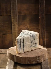 Foto auf Acrylglas Slice of blue cheese on wooden board on dark background © Eduard Zhukov
