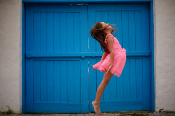 Llittle girl gymnast, performs various gymnastic and fitness exercises outdoor.