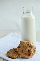 Cookies with chocolate on the table with a glass bottle of milk
