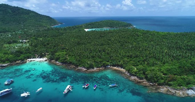 Aerial: Beautiful lagoon with speedboats and ships standing near the white send beach with turquoise water. Racha Island. Thailand.