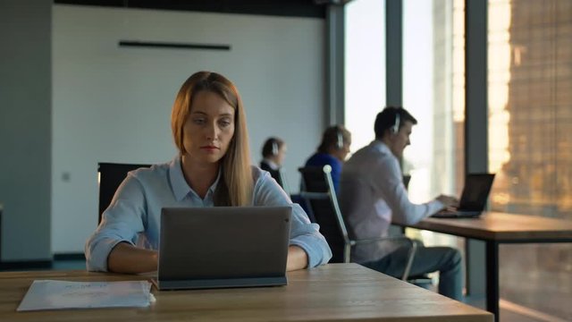 Boss businesswoman holding call-center agency in business office. She looks like confident and smart manager. Smiling while look at camera. Inside of modern building with business district window view