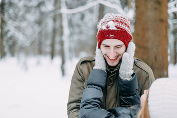 couple of young people in love walks in the winter forest. play with snow before christmas.