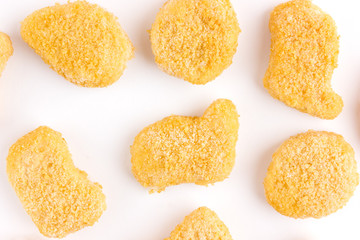 Frozen nuggets on a white background. Several chicken nuggets in breading close-up on a white background.