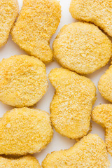 Frozen nuggets on a white background. Several chicken nuggets in breading close-up on a white background.