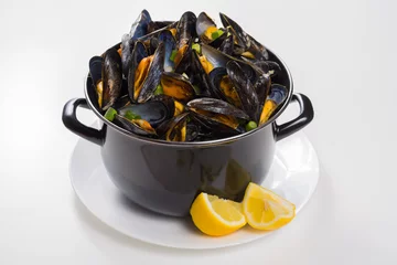 Plexiglas foto achterwand Black pan with cooked with green onion, parsley marinated high quality mussels © barmalini