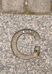 Letter G. On stone background