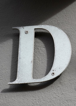 Letter D. On brown background