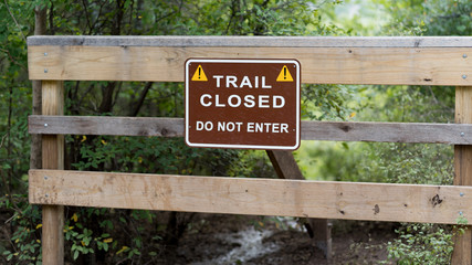 A sign on a closed walkway in a city park