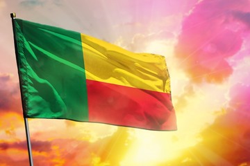 Fluttering Benin flag on beautiful colorful sunset or sunrise background. Success concept.