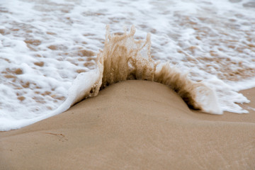 Olas del mar sobre la arena de la playa en la costa del Mediterráneo una mañana de verano con olas suaves rompiendo en la orilla