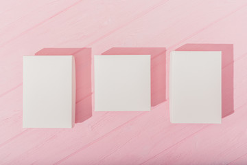 Top view three empty white boxes on pink wooden table