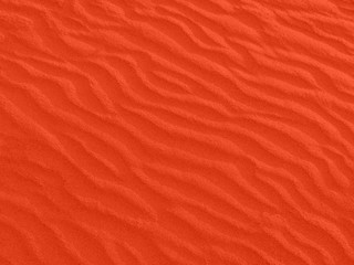 texture of red sand waves on the beach or in the desert. the ripples of the sand is diagonal.