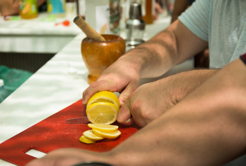 cropped view of man cutting yellow lemons Man slicing lemons in the kitchen. Picnic